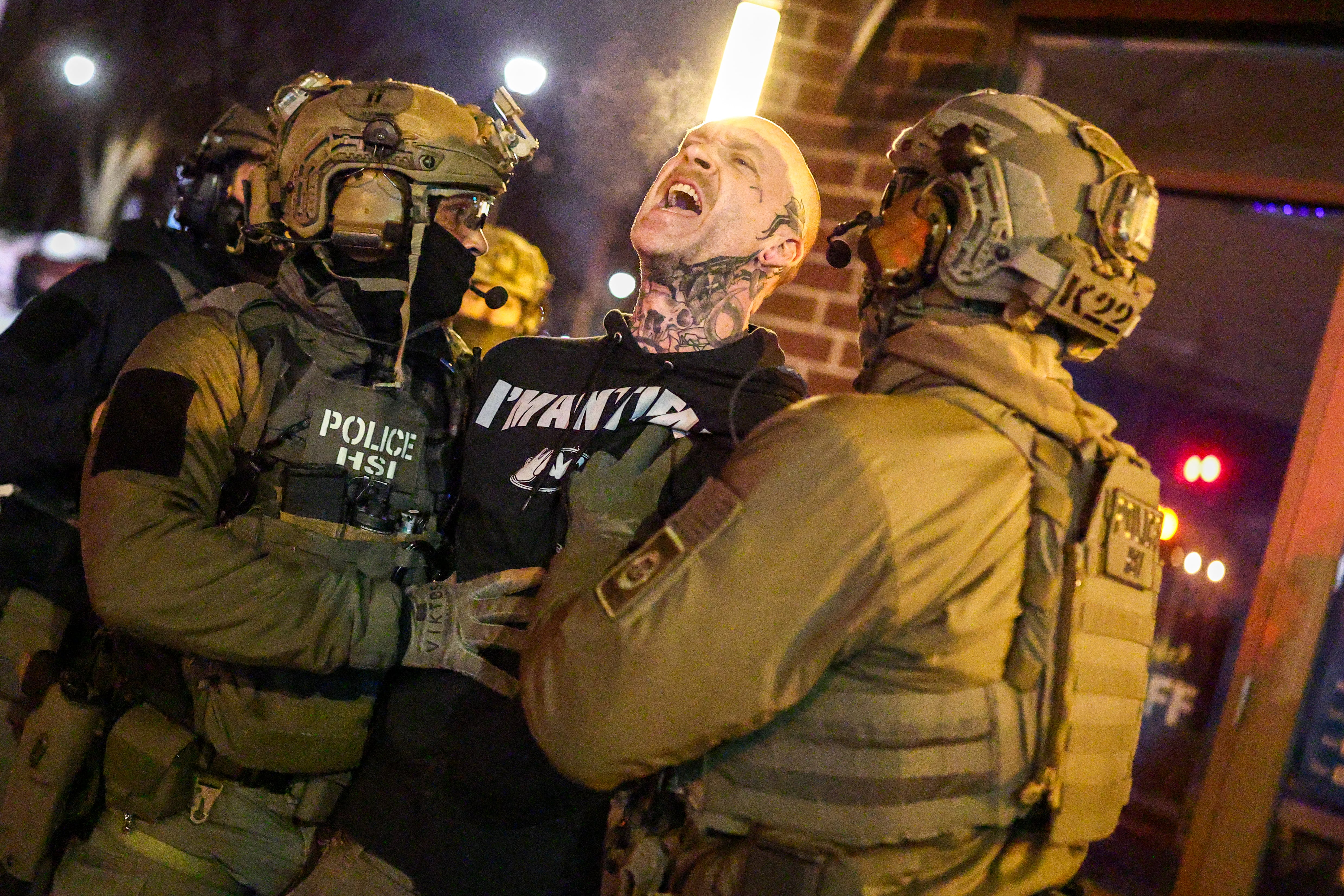 Federal agents with Homeland Security Investigations (HSI) detain a protestor wearing an "Antifa" shirt outsideMinneapolis, Minnesota, on February 5, 2026. US President Donald Trump suggested on February 4 that a "softer touch" may be needed on immigration, as his administration said 700 federal officers would be pulled from Minnesota but that mass deportations would not stop. The fatal shootings of two protesters by federal officers in Minneapolis a residential building in  last month sparked widespread outrage in the United States and calls for an end to immigration raids in the Midwestern city, but Trump's administration has been reluctant to shift course. (Photo by CHARLY TRIBALLEAU / AFP)