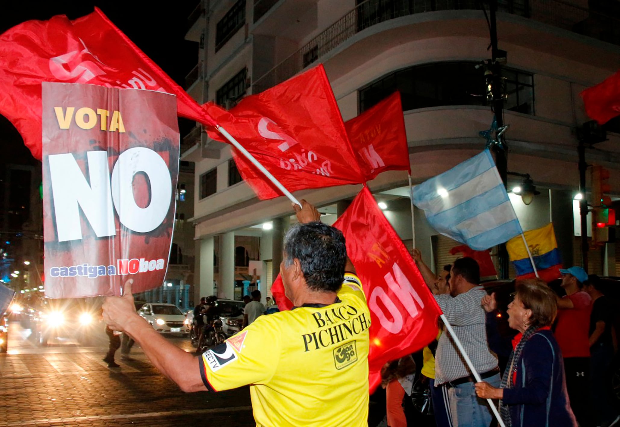 People celebrate following the first results of the constitutional reform referendum in Guayaquil, Ecuador on November 16, 2025. Ecuadoran voters appeared poised on November 16, 2025, to reject the return of US military bases, according to early referendum results, a damaging blow to Trump-friendly President Daniel Noboa. (Photo by Gerardo MENOSCAL / AFP)