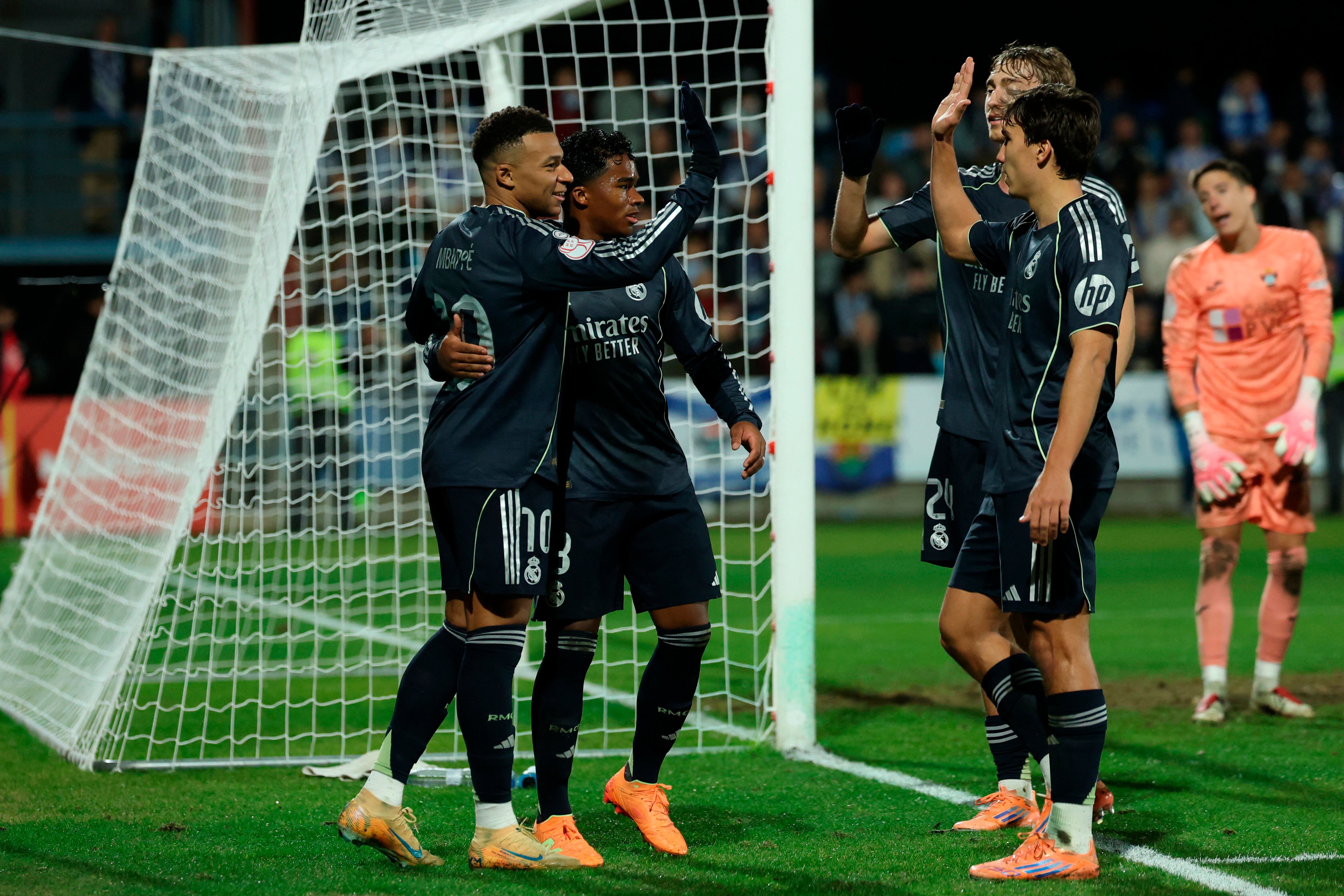 Real Madrid's French forward #10 Kylian Mbappe (L) and teammates celebrate after Talavera's own goal during the Spanish Copa del Rey (King's Cup) round of 32 second leg football match between Talavera CF and Real Madrid CF at El Prado Municipal Stadium in Talavera de la Reina on December 17, 2025. (Photo by Thomas COEX / AFP)