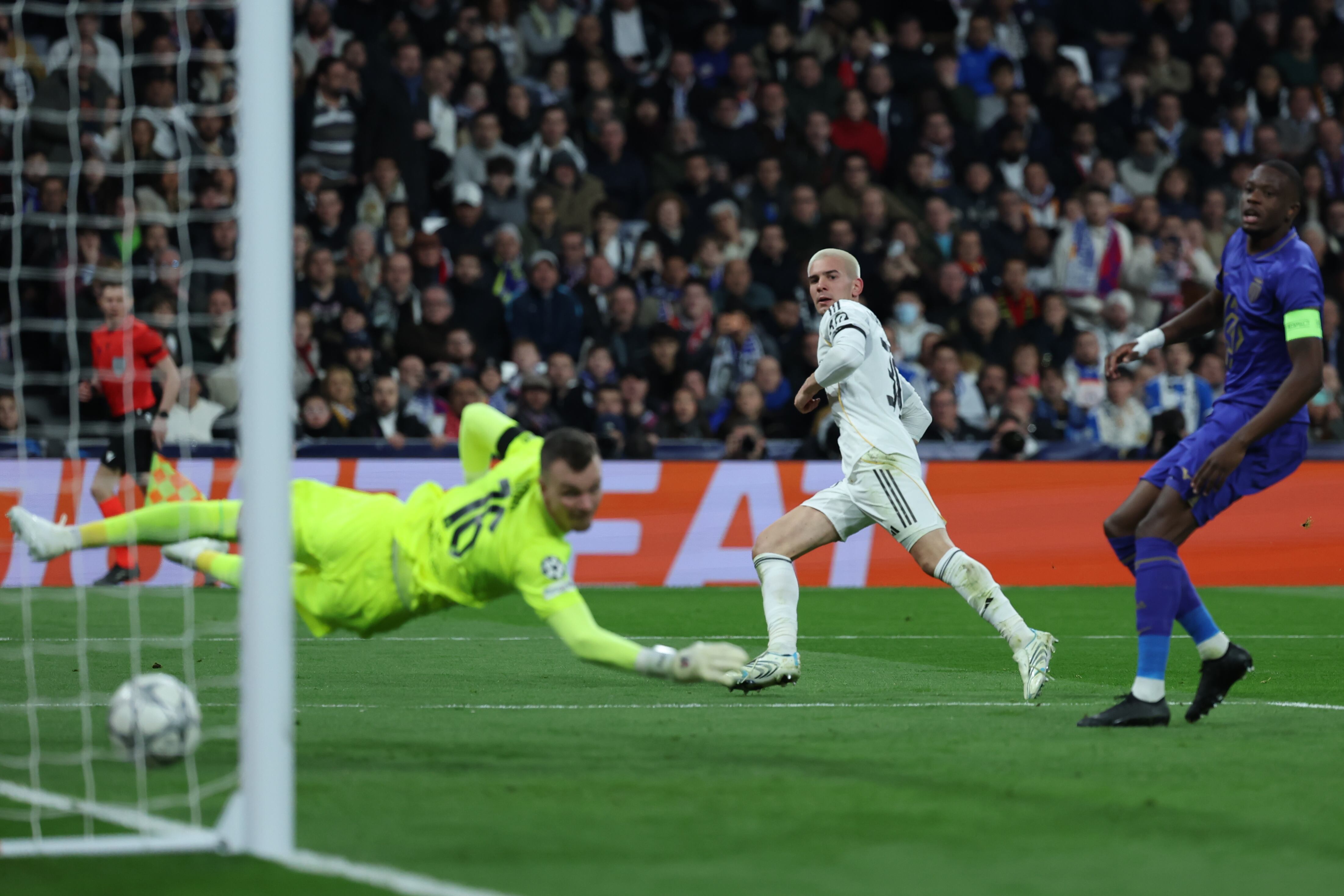 MADRID, 20/01/2026.- El guardameta alemán del AS Mónaco, Philipp Köhn (i), intenta detener el remate del centrocampista argentino del Real Madrid, Mastantuono, en la jugada que ha significado el tercer gol del equipo madridista durante el encuentro correspondiente a la Liga de Campeones UEFA que disputan hoy martes el Real Madrid y el AS Mónaco, en el estadio Santiago Bernabéu en Madrid. EFE/ Kiko Huesca.
