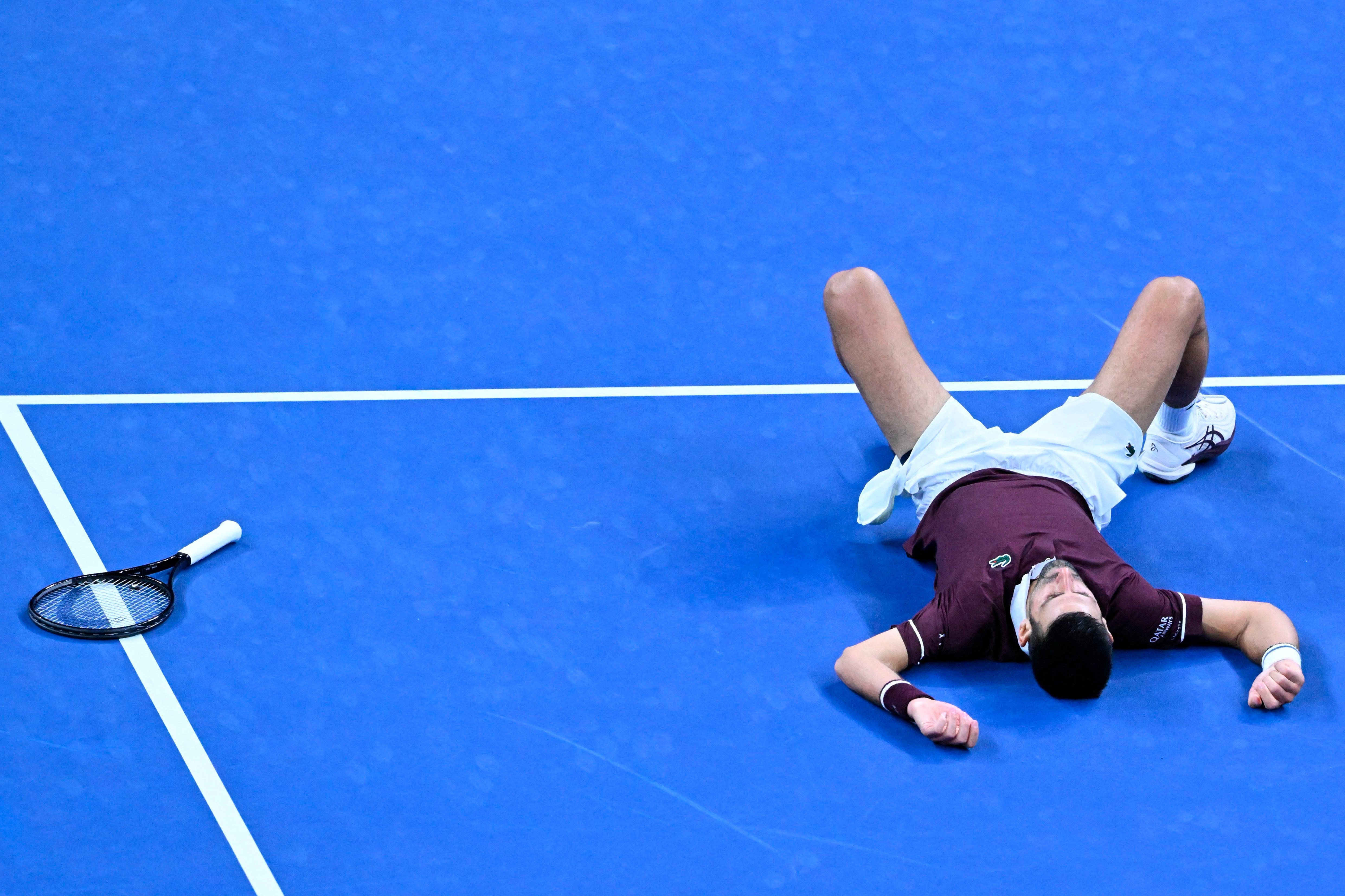 Serbia’s Novak Djokovic falls as he plays against Russia’s Daniil Medvedev during their men’s singles semi-final match at the China Open tennis tournament in Beijing on October 5, 2026. (Photo by ADEK BERRY / AFP)