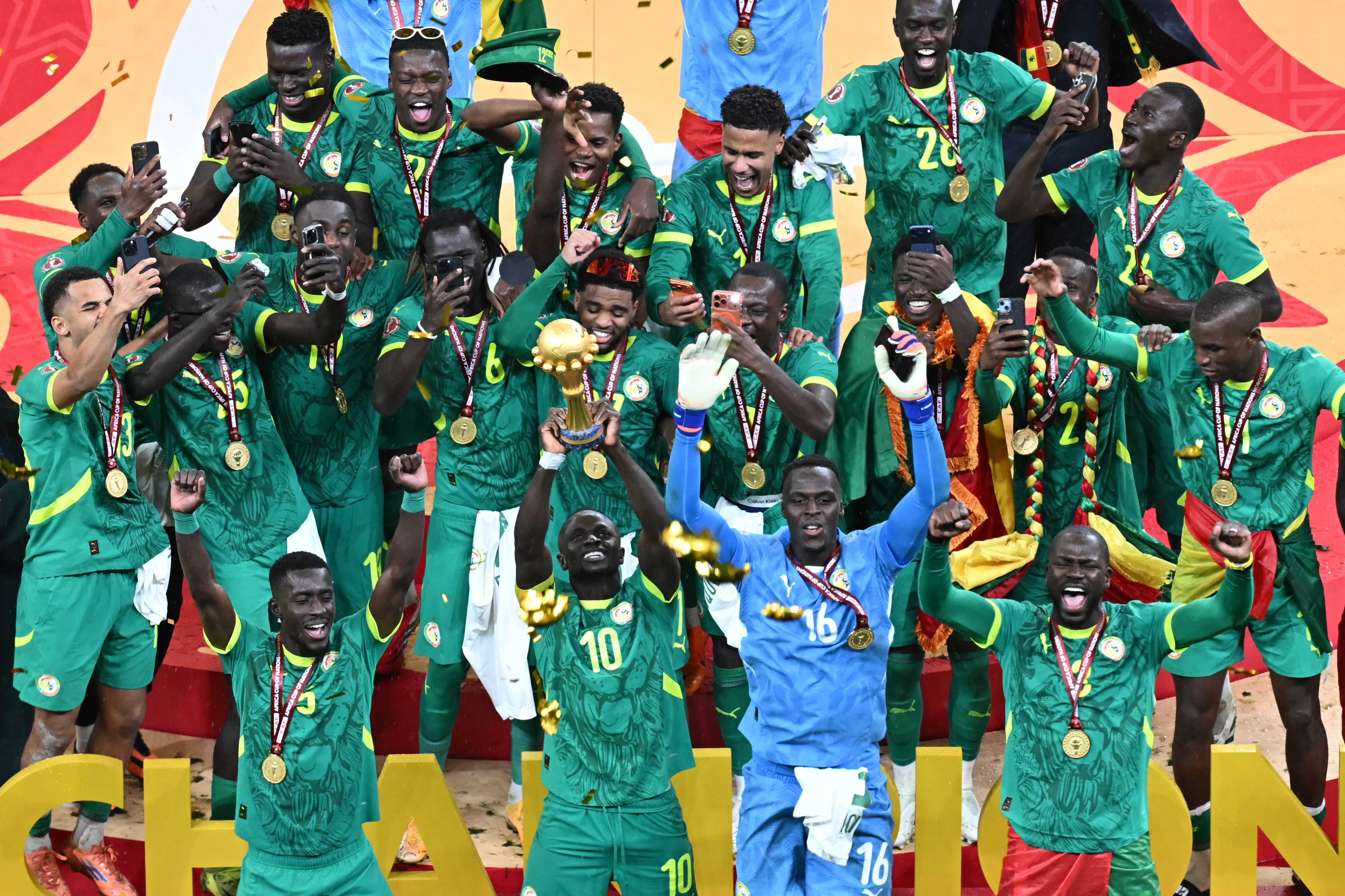 Senegal players celebrate with the trophy after winning the Africa Cup of Nations (CAN) final football match against Morocco at the Prince Moulay Abdellah Stadium in Rabat on January 18, 2026. (Photo by Paul ELLIS / AFP)