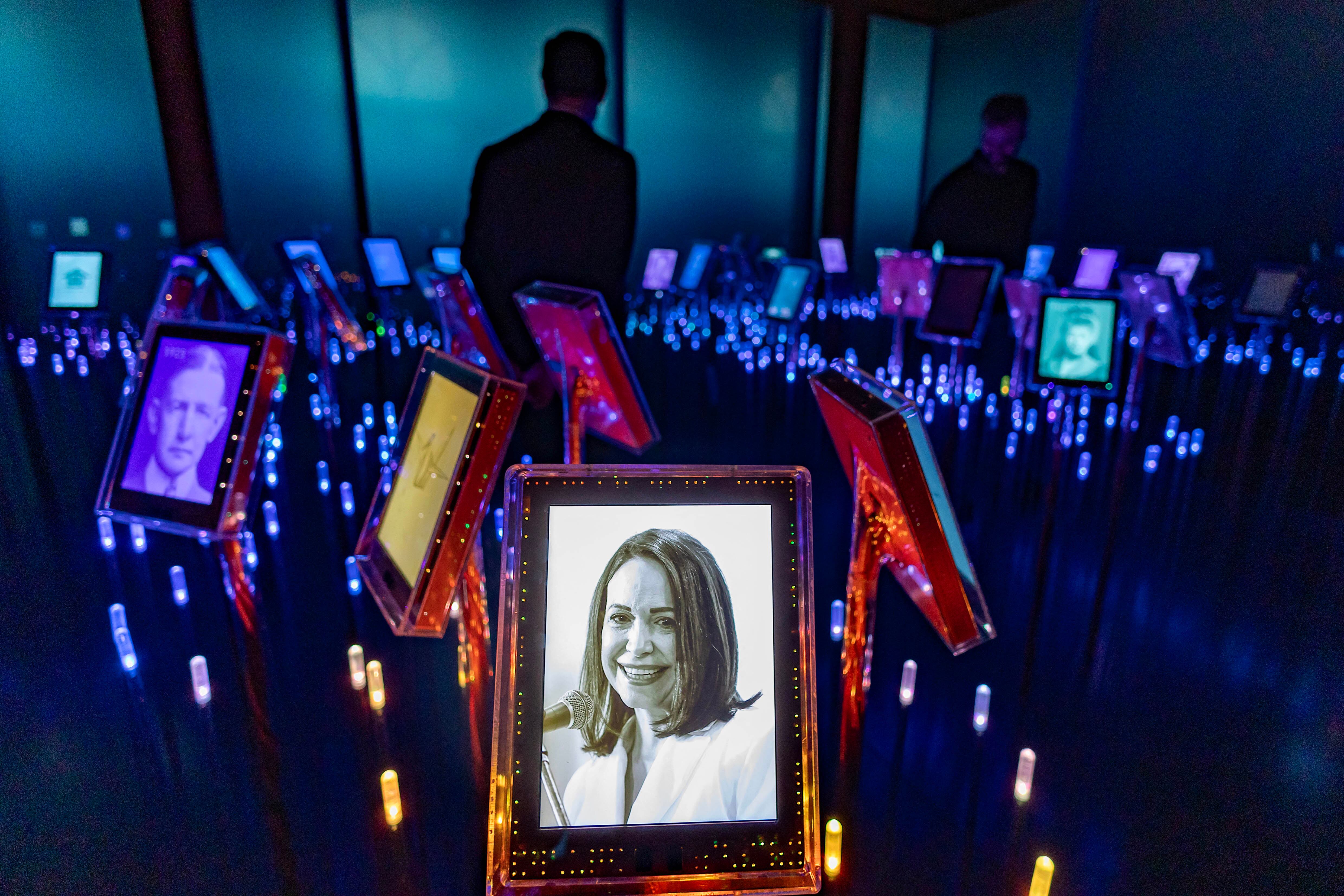A picture of Nobel Peace Prize laureate Maria Corina Machado is seen among portraits of previous winners in the "Nobel Field" at the exhibition "Democracy on the brink" in honour of the laureate at the Nobel Peace Center in Oslo on December 9, 2025, on the eve of the Nobel Peace Prize ceremony. The new exhibition featuring the 2025 laureate opens to the public on December 12, 2024. (Photo by Odd ANDERSEN / AFP)