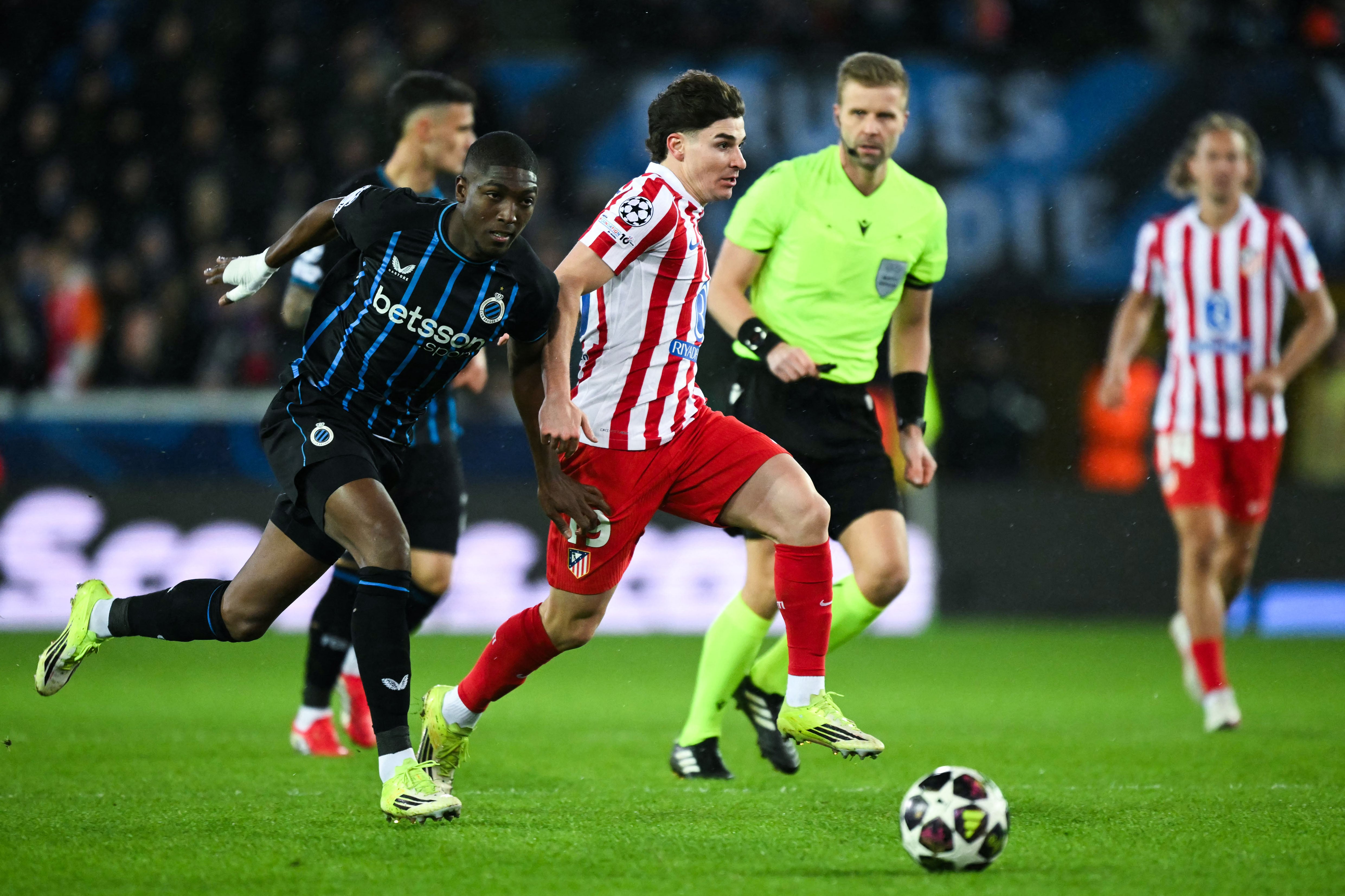 Atletico Madrid's Argentine forward #19 Julian Alvarez (C) and Club Brugge's Ecuadorian defender #04 Joel Ordonez fight for the ball during the UEFA Champions League knockout round play-off first leg football match between Club Brugge and Atletico Madrid at the Jan Breydel Stadium in Brugge on February 18, 2026. (Photo by NICOLAS TUCAT / AFP)