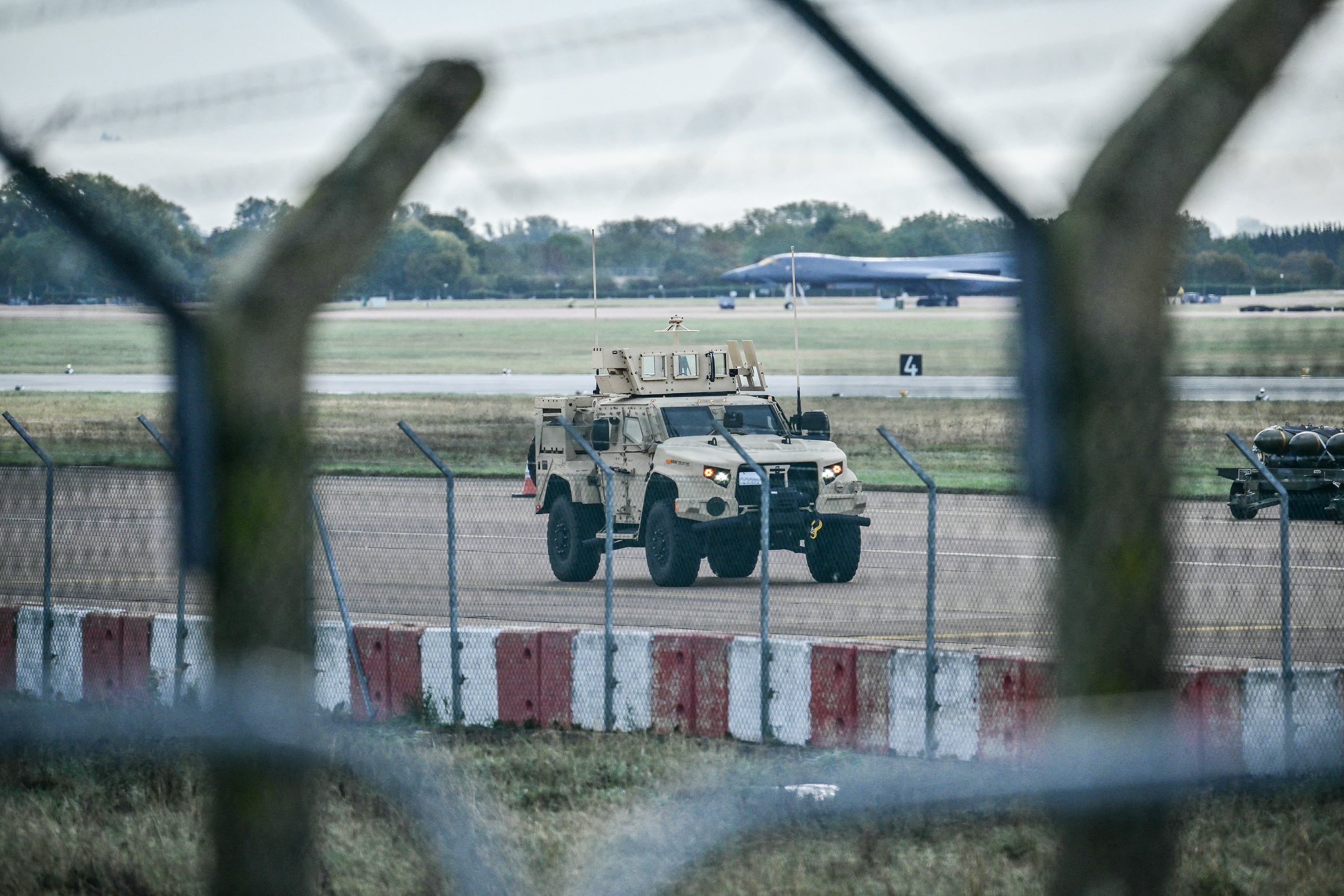 An armoured vehicle (C) patrols the interior at RAF Fairford base in Fairford, south-west England on September 28, 2026, a day after British counter-terrorism police were probing "a major" incident near the base. Armed officers detained a group of five men in the early hours after a call to emergency services about three "suspicious vehicles which appeared to be travelling towards the air base", London's Metropolitan Police said in a statement. (Photo by Ben STANSALL / AFP)