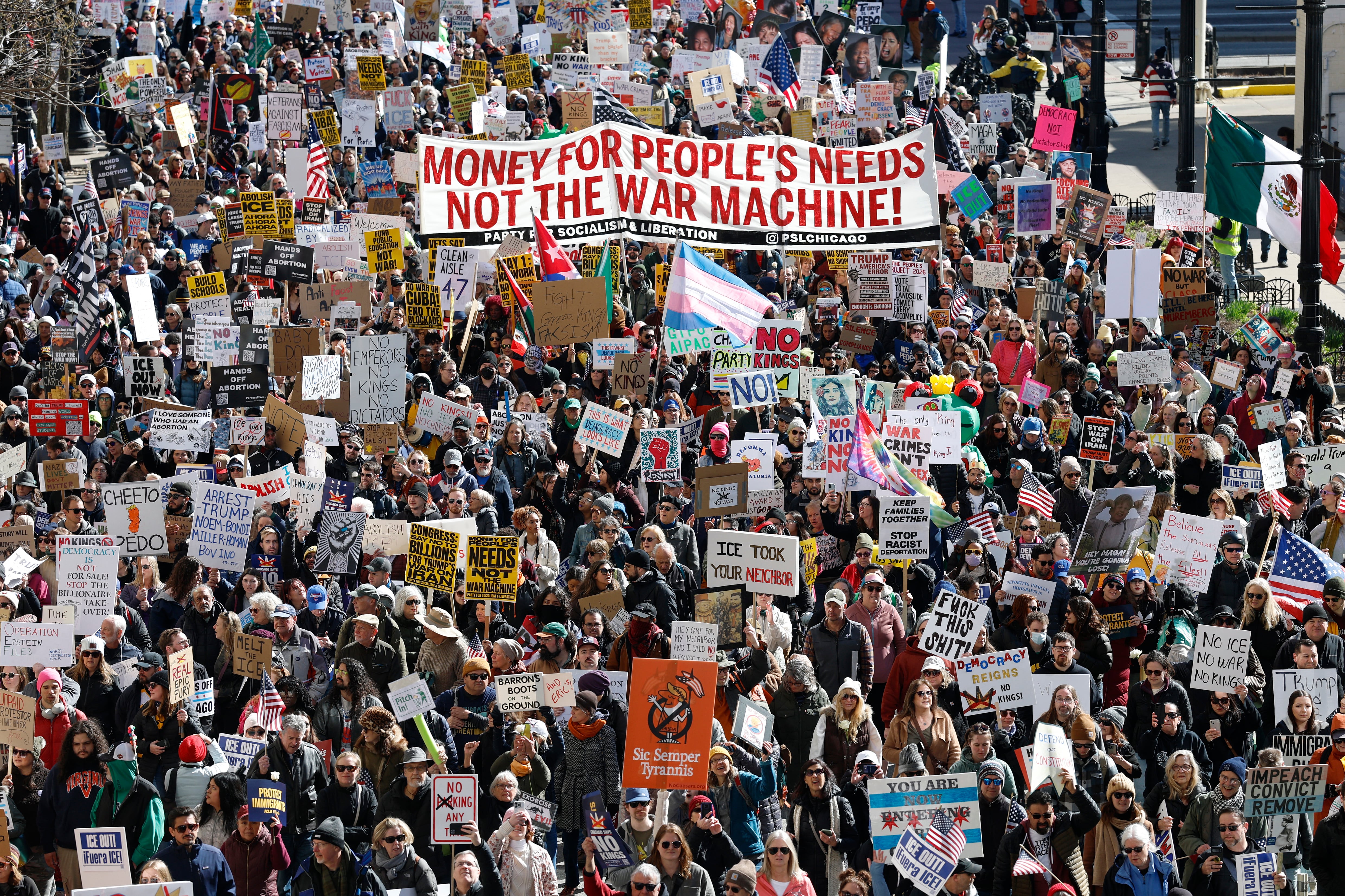 People hold signs and flags as they march during the "No Kings" national day of protest in Chicago on March 28, 2026. Nationwide protests against US President Donald Trump are expected Saturday as millions of people vent fury over what they see as his authoritarian bent and other forms of cruel, law-trampling governance. It is the third time in less than a year that Americans will take to the streets as part of a grassroots movement called "No Kings," the most vocal and visual conduit for opposition to Trump since he began his second term in January 2025. (Photo by KAMIL KRZACZYNSKI / AFP)