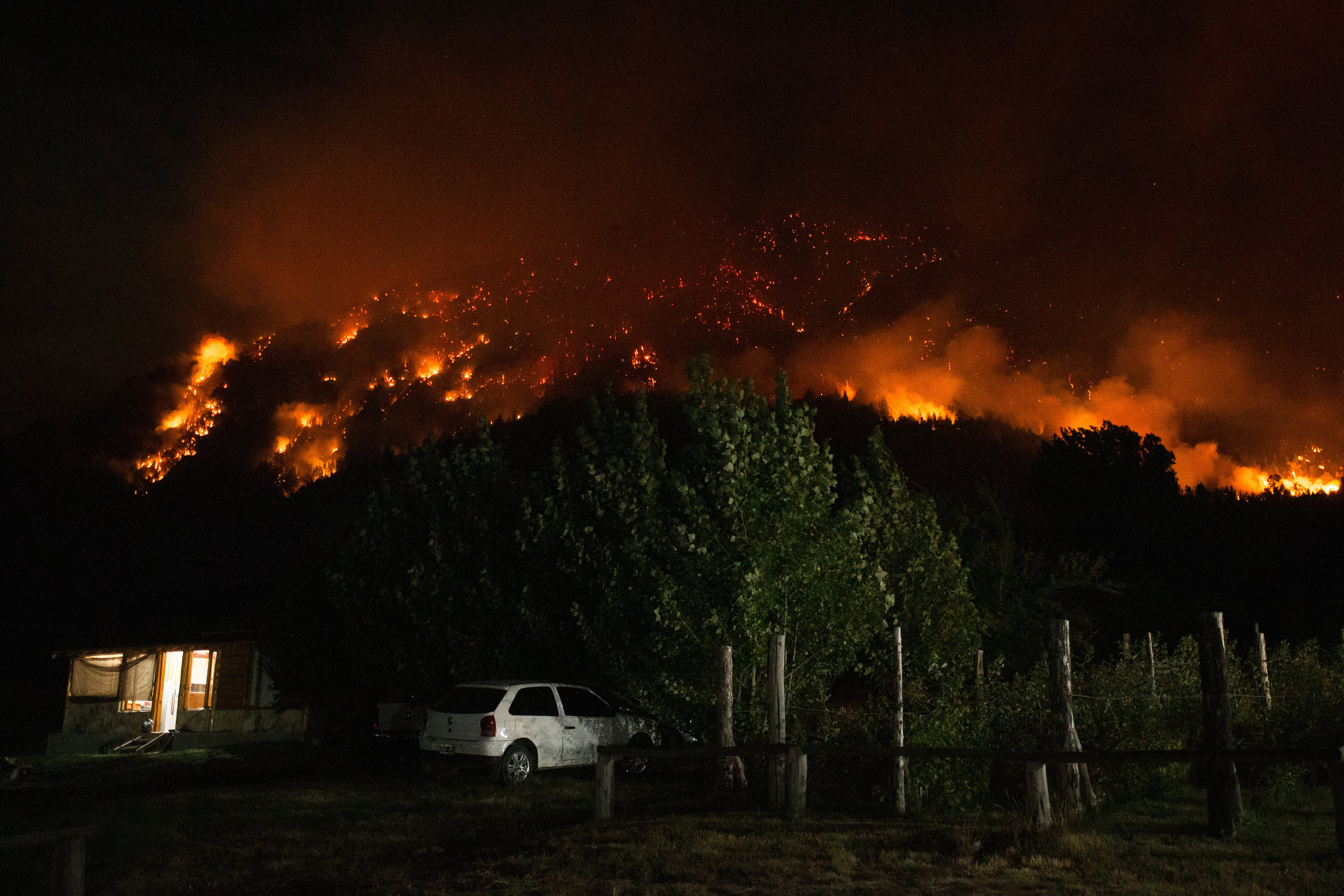 A forest fire is pictured engulfing Mount Pirque at El Hoyo, in the Patagonian region of Chubut province, Argentina on January 7, 2026. Thousands of hectares of forest were devastated by fire on January 6, in Argentine Patagonia, where a red alert is in effect due to extreme conditions, one year after the region experienced its worst wildfires in three decades. (Photo by Martin LEVICOY / AFP)