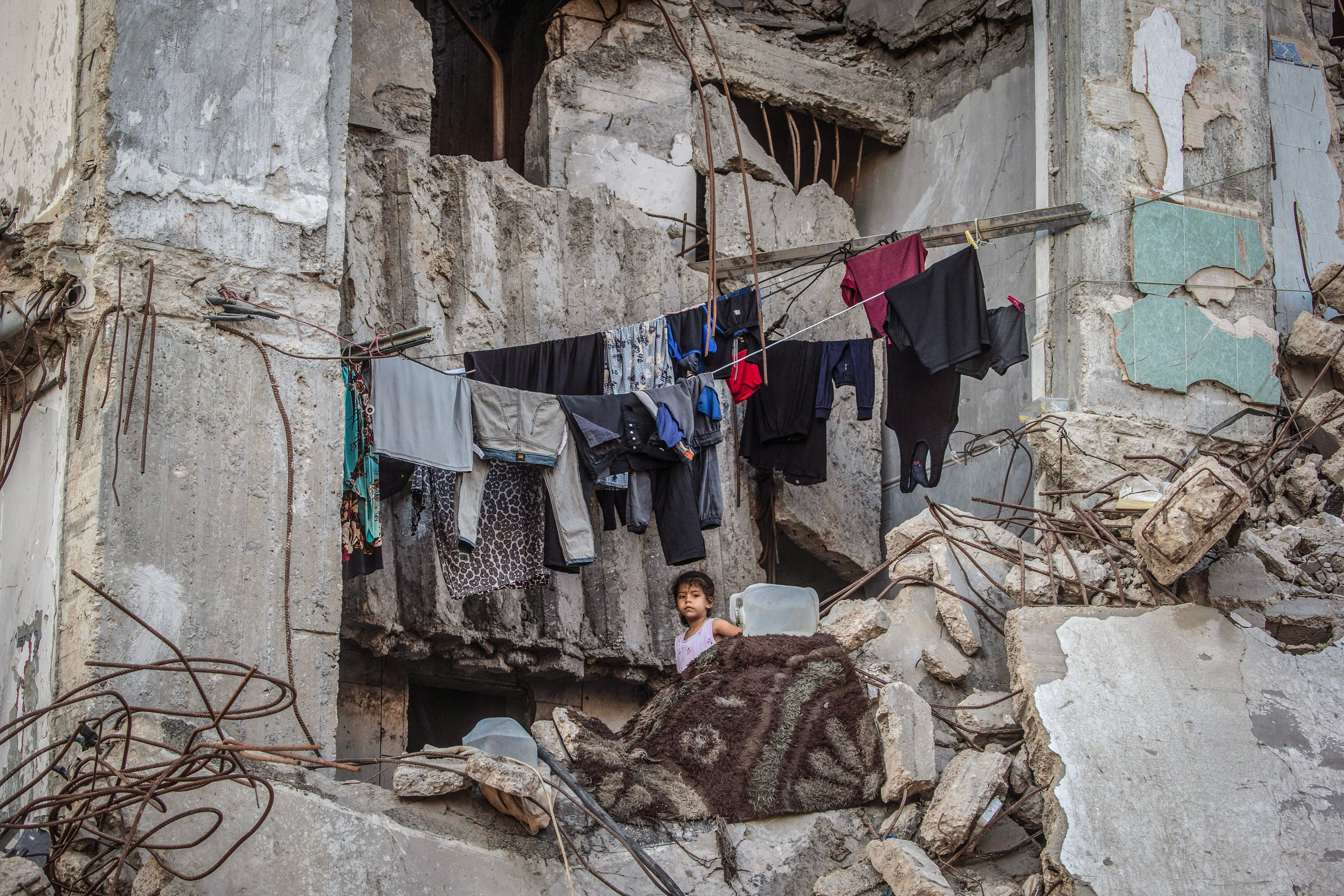 Gaza City (-), 21/09/2026.- A displaced Palestinian girl stands next to hanging clothes inside a damaged building where she lives with her family in Gaza City