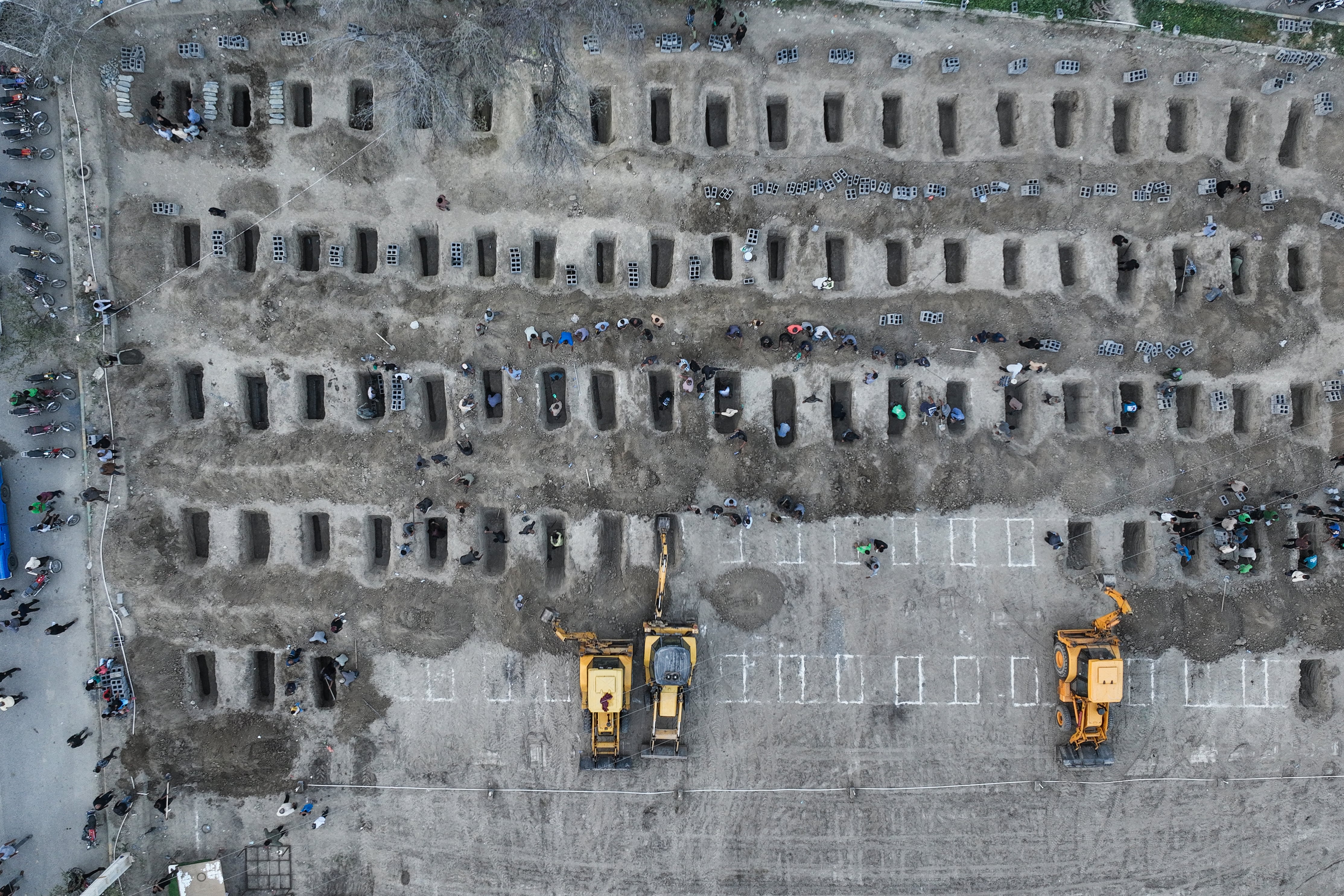 In this aerial handout picture released by the Iranian Press Center, mourners dig graves during the funeral for children killed in a reported strike on a primary school in Iran’s Hormozgan province in Minab on March 3, 2026. Iranian media have reported hundreds of Iranian casualties, including at a girl's school, although AFP reporters have not been able to verify tolls independently. The war launched by the United States and Israel against Iran spread across the Middle East, threatening to plunge the global economy into chaos, with Lebanon and Gulf energy exporters dragged into the conflict. (Photo by Iranian Press Center / AFP) / XGTY / RESTRICTED TO EDITORIAL USE - MANDATORY CREDIT "AFP PHOTO / IRANIAN PRESS CENTER" - HANDOUT - NO MARKETING NO ADVERTISING CAMPAIGNS - DISTRIBUTED AS A SERVICE TO CLIENTS