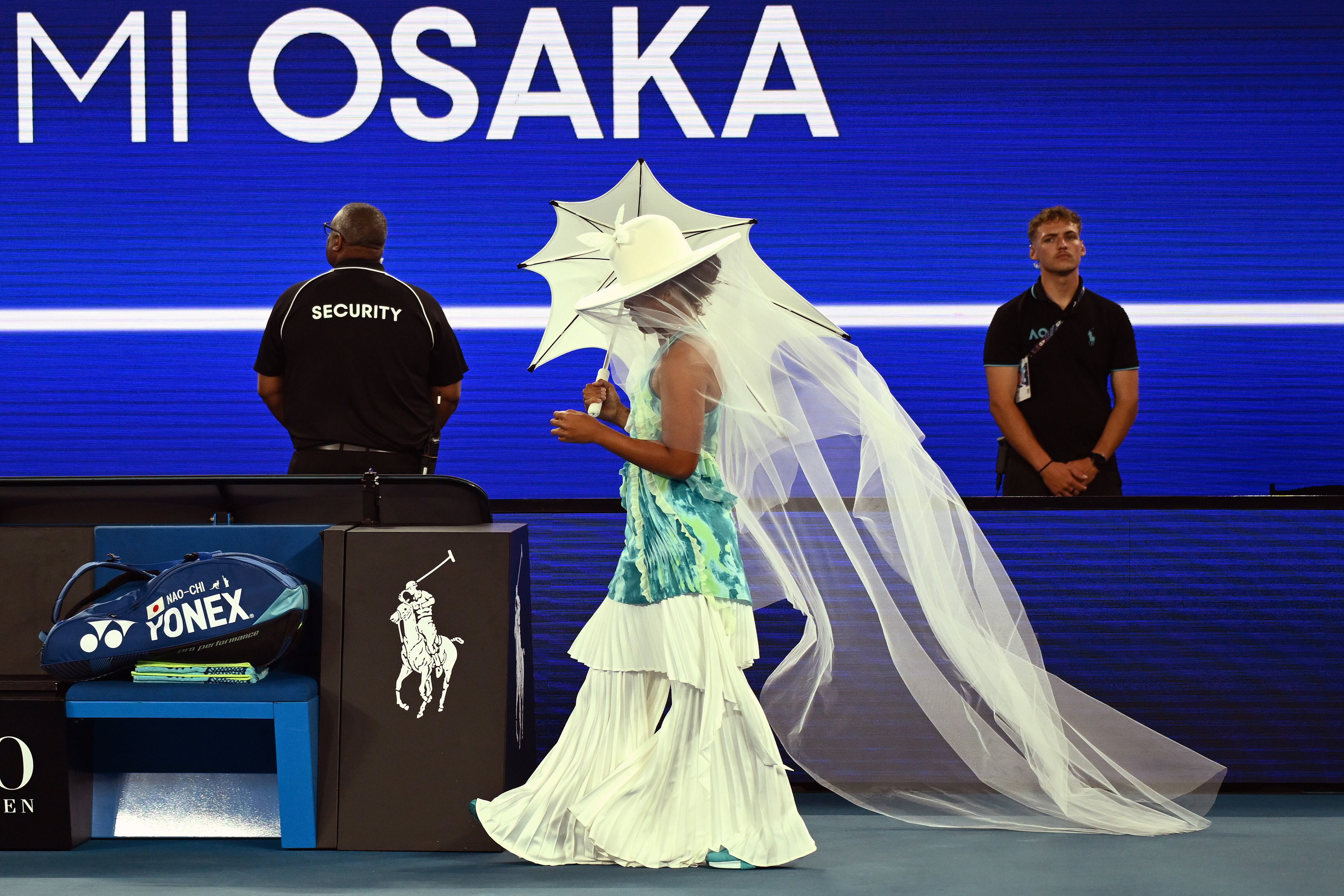 FOTODELDIA MELBOURNE, 20/01/2026.- La tenista japonesa Naomi Osaka hace su entrada en pista con vestido largo, velo, sombrilla y sombrero, antes de su partido de primera ronda del Open de Australia ante la croata Antonia Ruzic, este martes en Melbourne. EFE/ Joel Carrett PROHIBIDO SU USO EN AUSTRALIA Y NUEVA ZELANDA