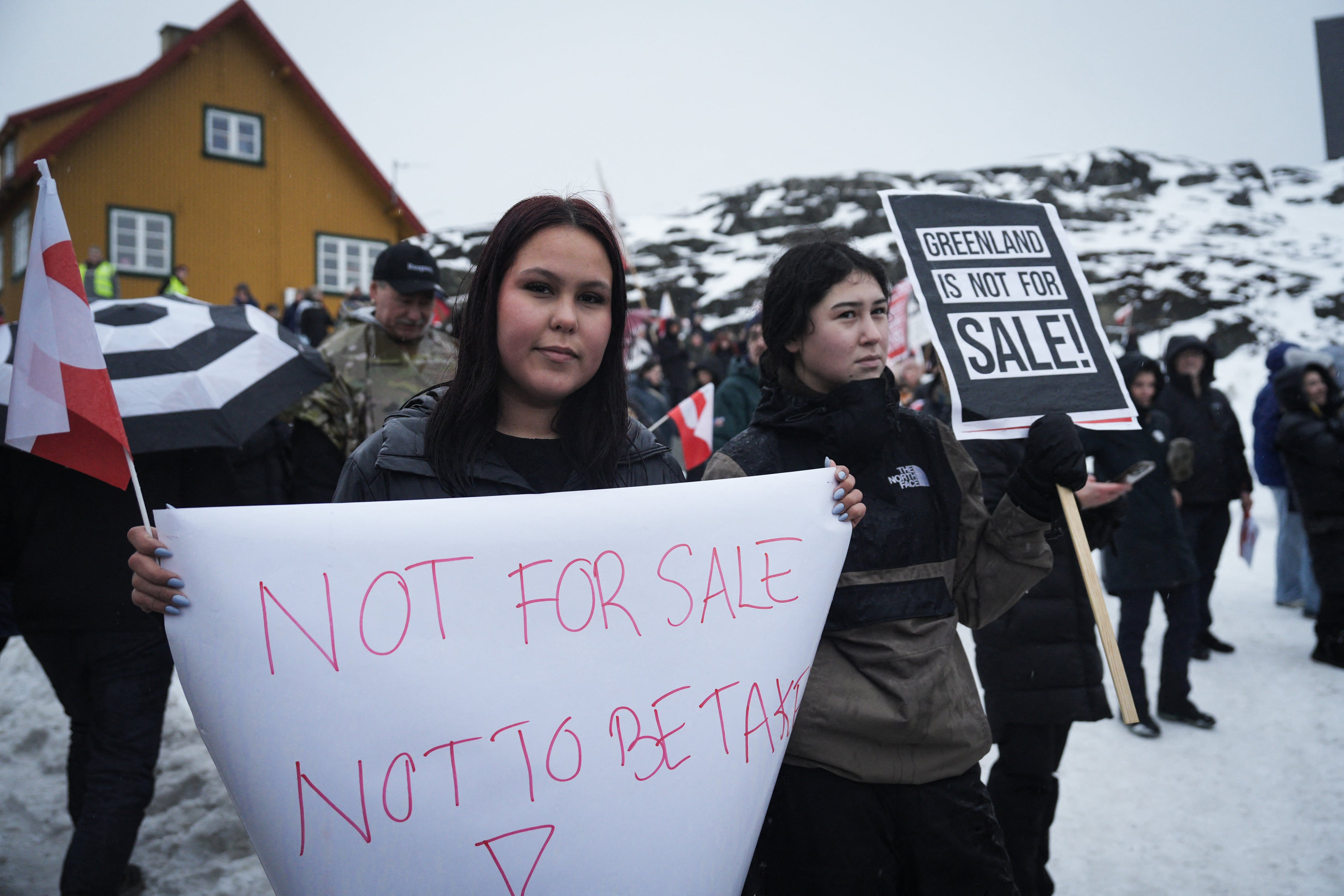 Young people with placards reading "Greenland is not for sale!" take part in a demonstration that gathered almost a third of the city population to protest against the US President's plans to take Greenland, on January 17, 2026 in Nuuk, Greenland, near the US Consulate to Greenland. US President Donald Trump escalated his quest to acquire Greenland, threatening multiple European nations with tariffs of up to 25 percent until his purchase of the Danish territory is achieved. Trump's threats came as thousands of people protested in the capital of Greenland against his wish to acquire the mineral-rich island at the gateway to the Arctic. (Photo by Alessandro RAMPAZZO / AFP)